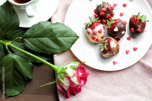 Tray with tasty glazed strawberries and beautiful flower