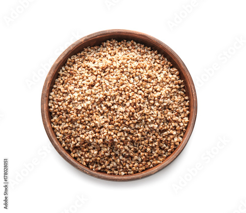 Plate with cooked buckwheat on white background