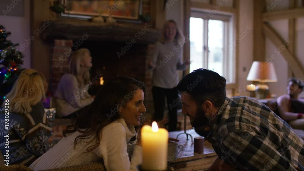 Happy family together at Christmas playing charades by the fire Happy family together at Christmas playing charades by the fire