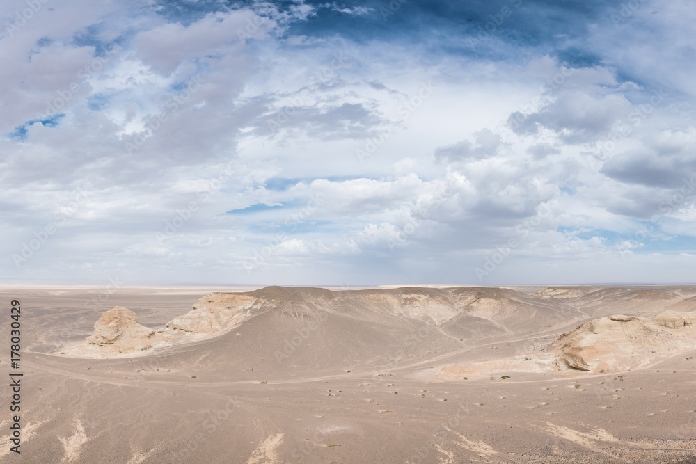 Naklejka premium beautiful sunlit white desert with fluffy clouds on blue sky 