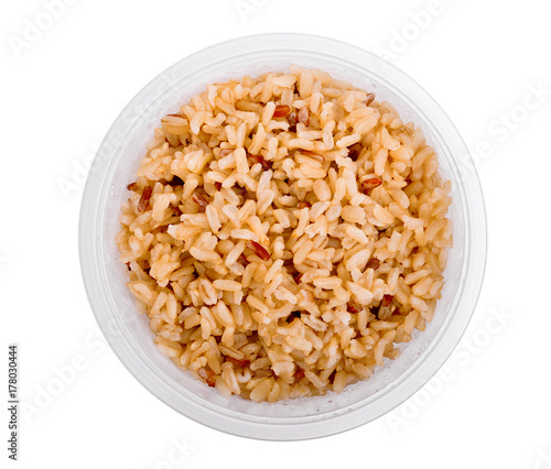 Canvas-taulu top view of brown rice in plastic cup isolated on white background