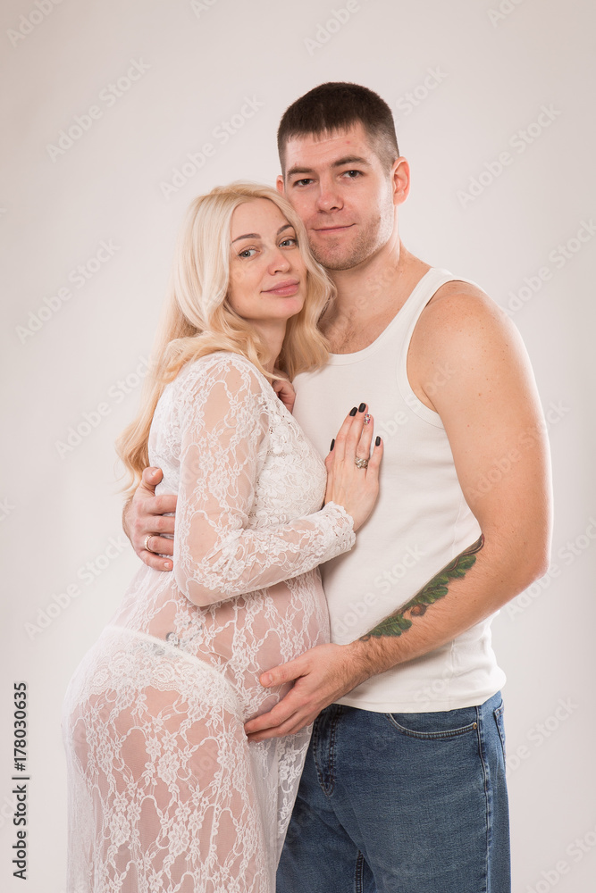 Beautiful pregnant couple in love on the background. Hands of husband on the tummy of his pregnant wife. Young man tenderly stroked pregnant belly of his wife. Husband kissing pregnant belly. Beautiful pregnant couple in love on the background. Hands of husband on the tummy of his pregnant wife. Young man tenderly stroked pregnant belly of his wife. Husband kissing pregnant belly.