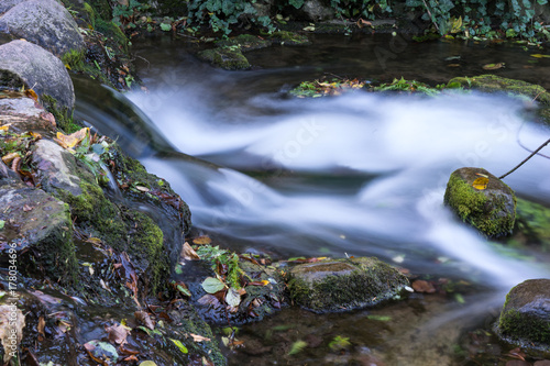 long exposure photo of a small waterfall falling down the stream