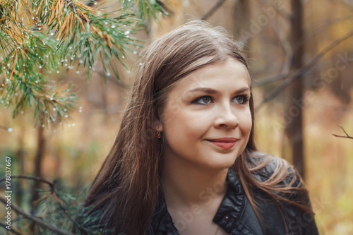 Portrait of nice girl in a forest in an autumn