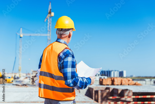 construction worker holding building plans