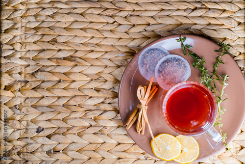 White porcelain cup of tea with cinnamon sticks, lemon, mint leaves and tea strainer photo