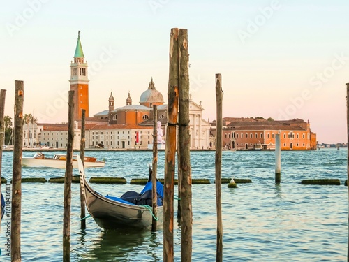 Gondolas moored in the Venetian lagoon. San Giorgio di Maggiore church as background. Venice, Italy