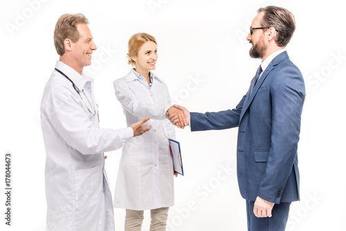 smiling businessman and doctors