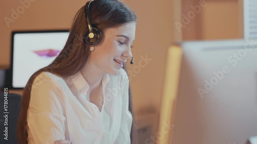 Attractive professional woman with a lovely radiant smile wearing a headset and microphone , conceptual of a receptionist, call center or public relations
