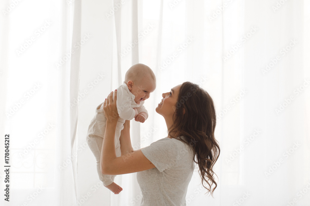 Cheerful woman playing with adorable infant child. Cheerful woman playing with adorable infant child.
