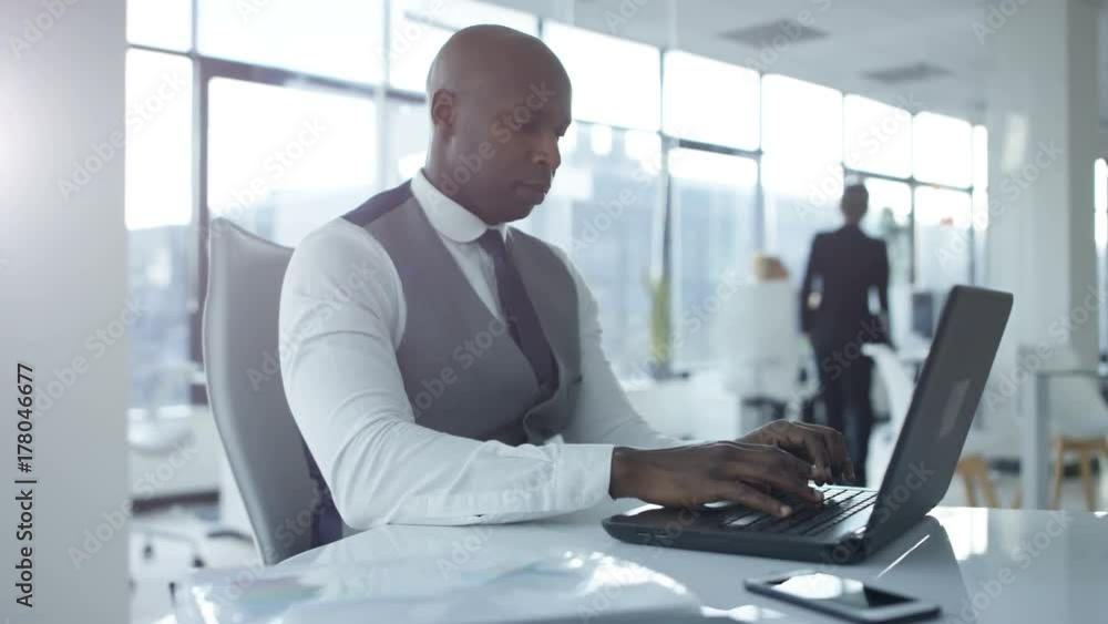 Financial businessman working at his desk, looking at paperwork with charts and graphs. Financial businessman working at his desk, looking at paperwork with charts and graphs.