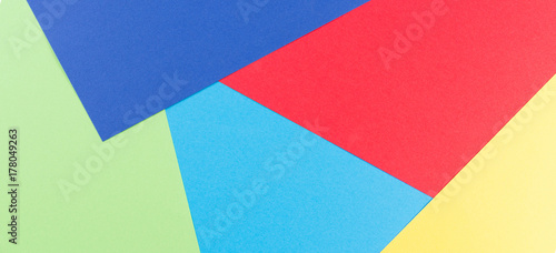 Color papers flat composition as banner background with yellow, green, red and blue tones