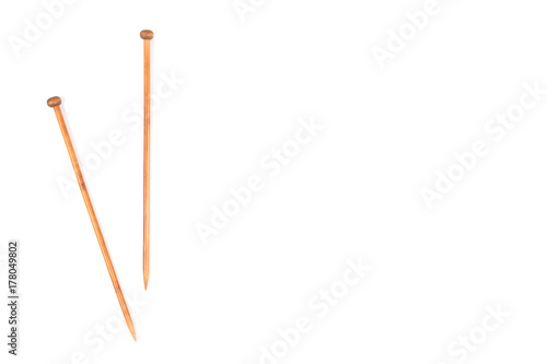 A pair of wooden knitting needles on white background.