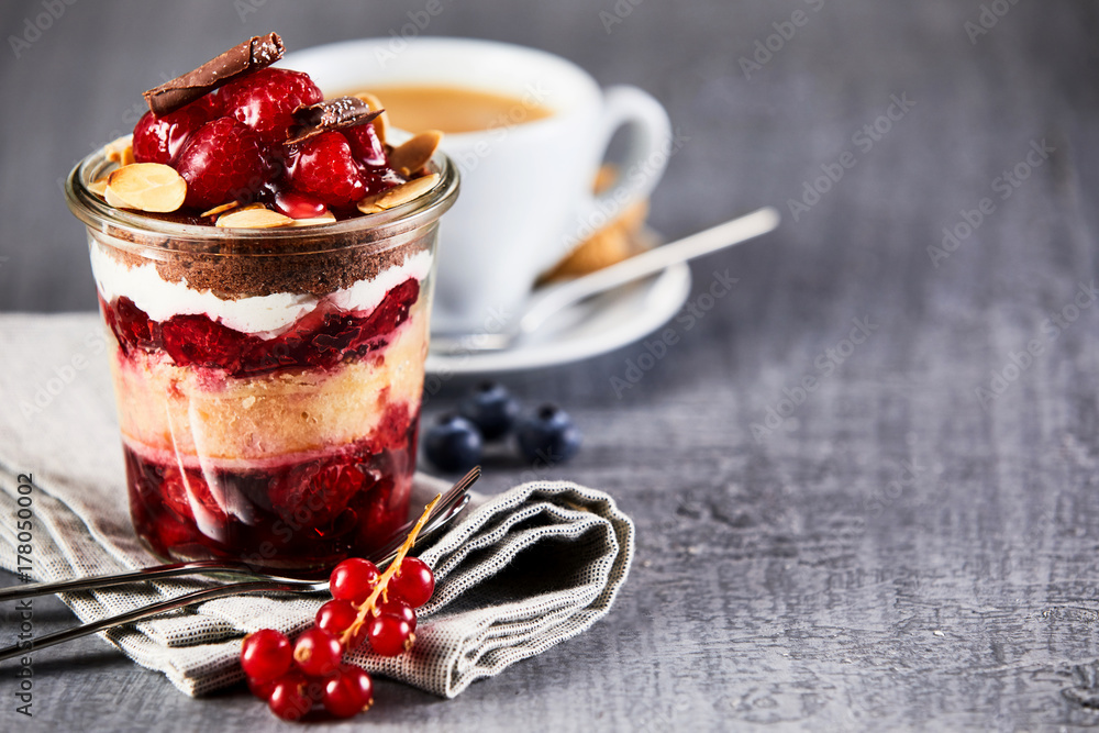 Layered fruit dessert in jar with cup of coffee - obrazy, fototapety, plakaty 