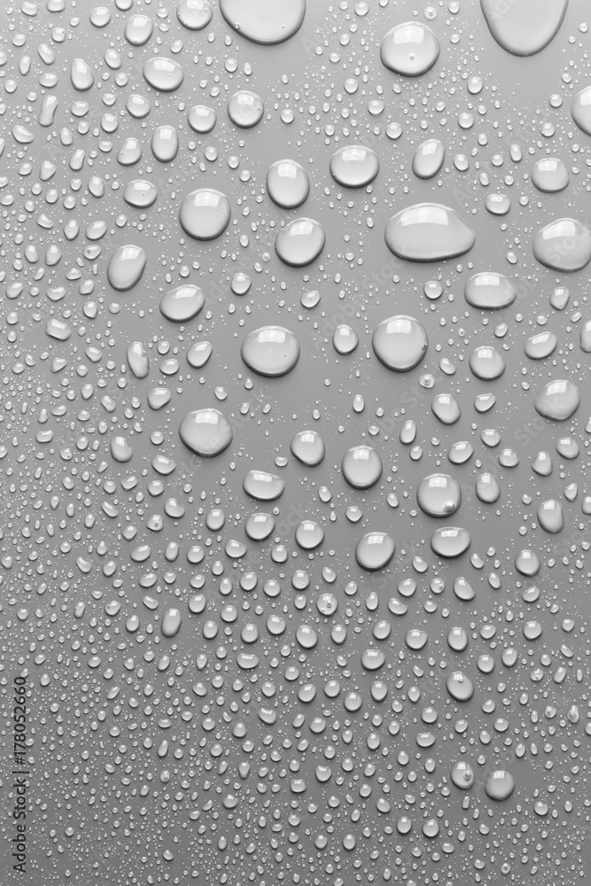 Surface with water drops, grey background.