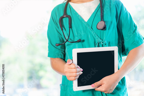 Young woman doctor with a tablet.