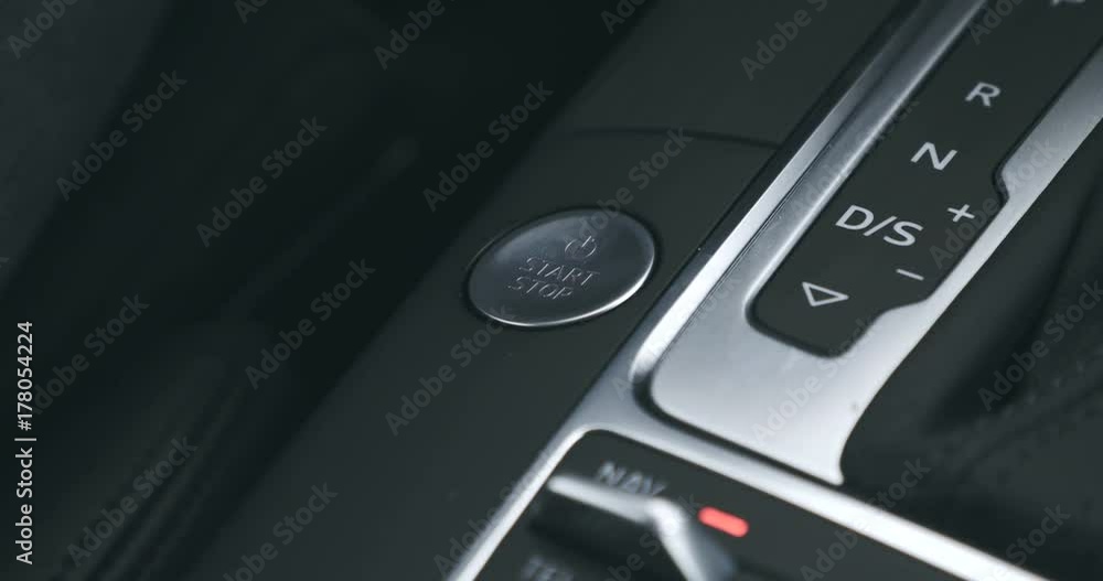 An extreme close of a person's finger pressing the start/stop button of a car. An extreme close of a person's finger pressing the start/stop button of a car.