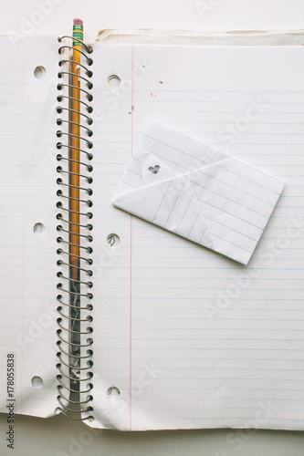 folded love note on an open notebook with pencil