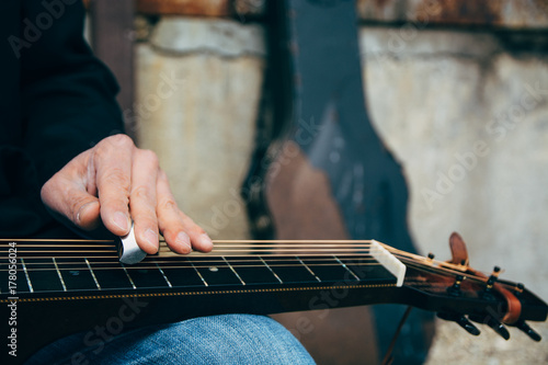 Closeup of A Male Musician's Hands Playing Slide Guitar