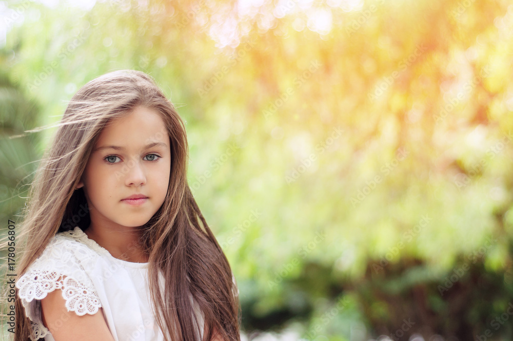 Beautiful little girl in the park, with long hair and and a sweet, gentle look. Happy childhood concept. Beautiful little girl in the park, with long hair and and a sweet, gentle look. Happy childhood concept.