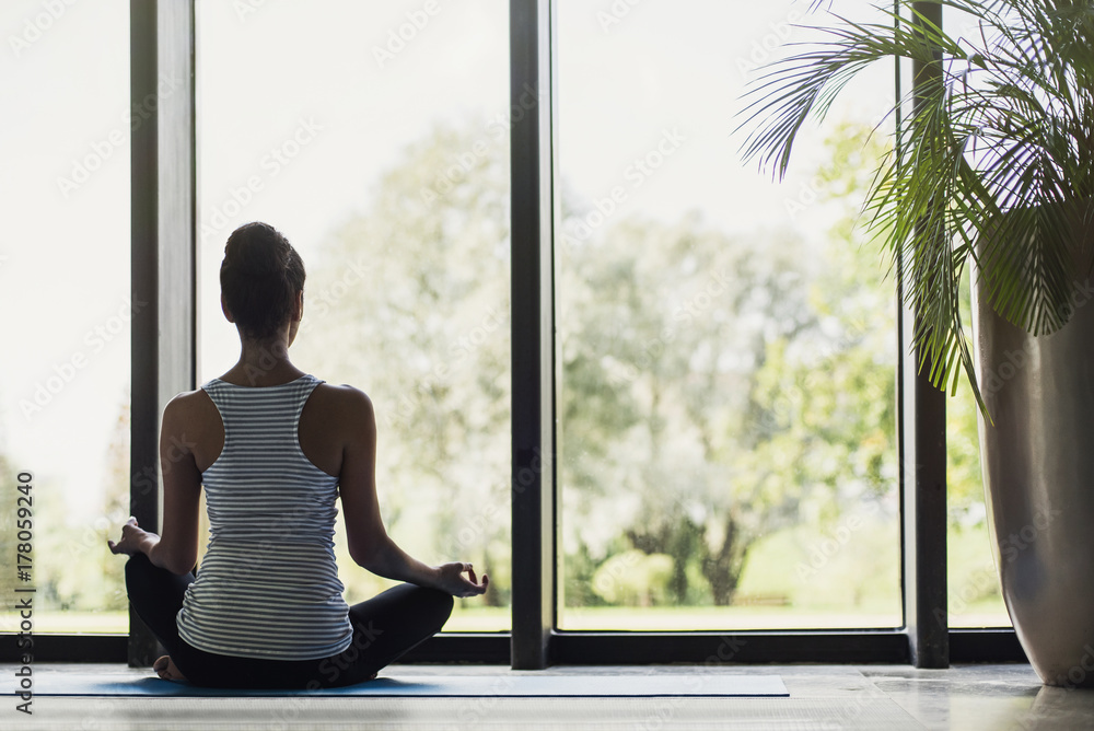 Woman meditating at home. Girl practicing yoga in class. Relaxation, meditation, self care, mindfulness, yoga training exercises concept.
