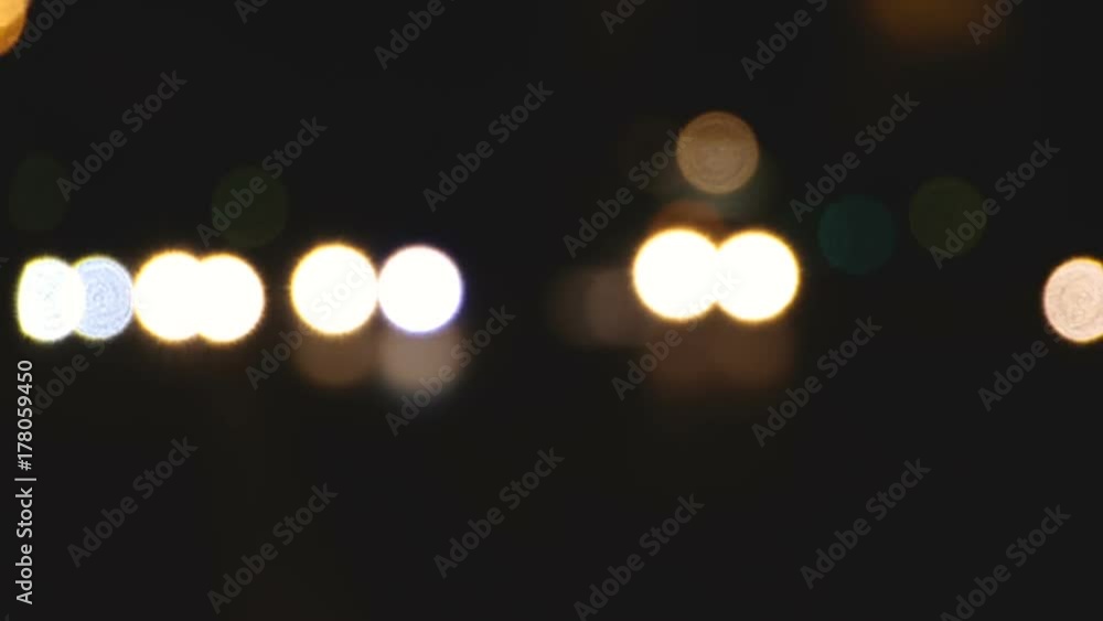 A bokeh shot of shifting light patterns of different colors followed by a transition to focus of city night life. Rack focus. A bokeh shot of shifting light patterns of different colors followed by a transition to focus of city night life. Rack focus.