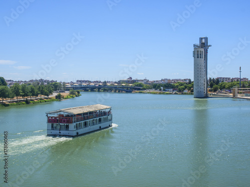 Barco con turista frente a la torre Schindler por el río Guadalquivir / Boat with tourist in front of the Schindler tower along the Guadalquivir river. Sevilla