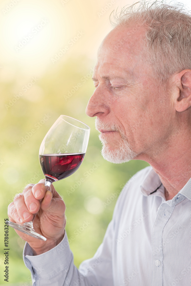 Mature man tasting red wine, light effect Mature man tasting red wine, light effect