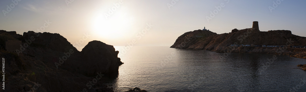 Corsica, 30/08/2017: tramonto sul Faro della Pietra (1857) e sulla torre genovese (XV secolo) sull'Isola della Pietra, promontorio roccioso di Isola Rossa, città dell'Alta Corsica 