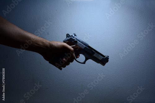 the killer man,a man holding a gun in darken light