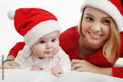 Christmas together-happy mother and girl in Santa hat. In Studio on white background isolated