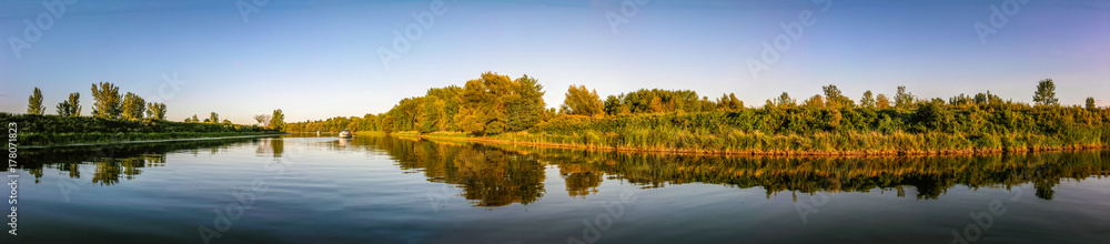 Panoramic view of a river with boat at anchor