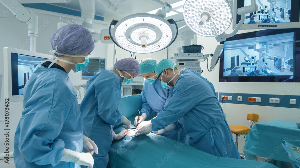 Medical Team Performing Surgical Operation in Bright Modern Operating Room Medical Team Performing Surgical Operation in Bright Modern Operating Room