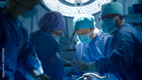 Medical Team Performing Surgical Operation in Modern Operating Room photo