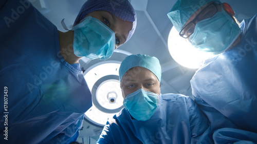 Low Angle Shot of Team of Doctors and Nurses looking Into camera. Patient Point of View.