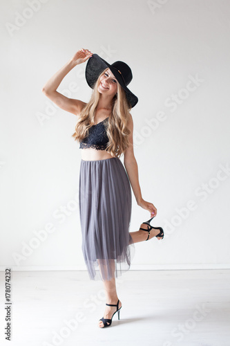 fashionable girl in a hat with a brim poses for advertising photo