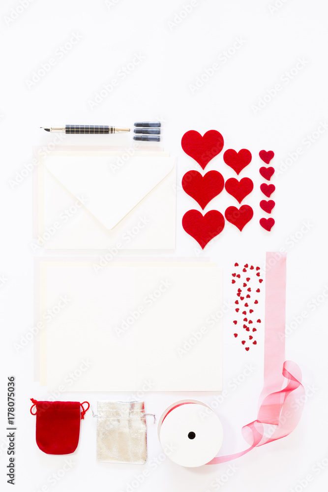 Display of love letter items on white background. Assortment of cards, envelopes, hearts, ribbon and ink pen. Display of love letter items on white background. Assortment of cards, envelopes, hearts, ribbon and ink pen.