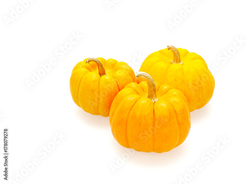 Three orange pumpkins in big, medium, and small size isolated on white background show colorful pattern and scale used in Halloween, still life, kitchen, and comparison themes