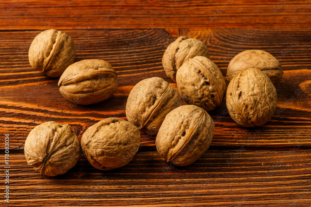 A few ripe walnuts on an old wooden background A few ripe walnuts on an old wooden background