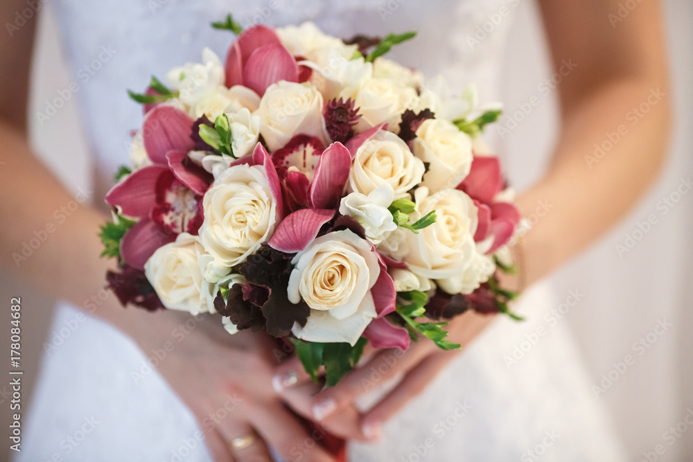 wedding bouquet of white and pink peonies and roses in bride hands