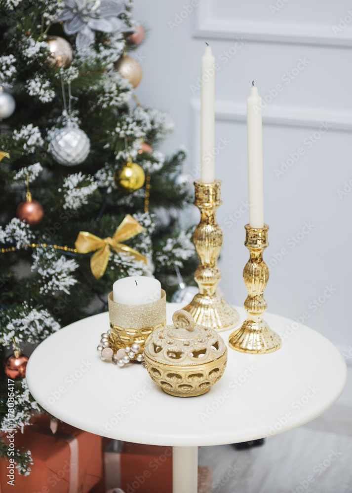 New Year's decorations on the table, candles in gold candlesticks, a box