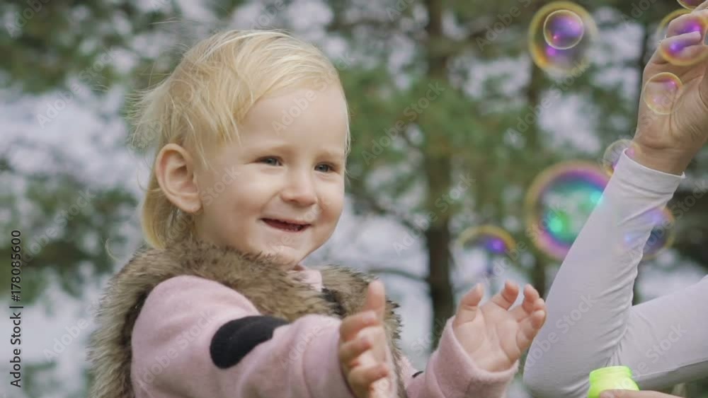Smiling mother with baby blowing air bubbles. Portrait of happiness Smiling mother with baby blowing air bubbles. Portrait of happiness