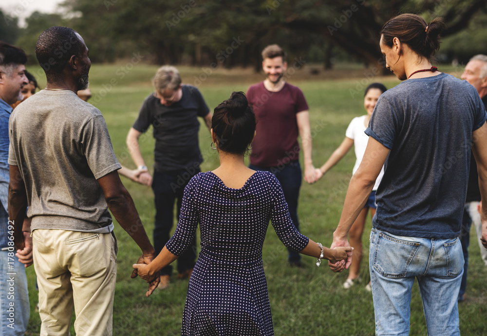 Group of people holding hand together in the park Group of people holding hand together in the park