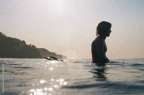 Surfer sits relaxed on his surfboard photo