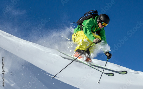 A skier is jumping off a windlip and does off-piste skiing at the Arlberg region in Austria. photo