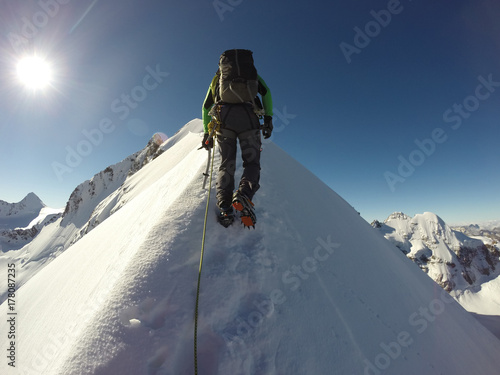 A mountaineer climps his way to the peak of Piz Bernina in the Swiss Alps. photo