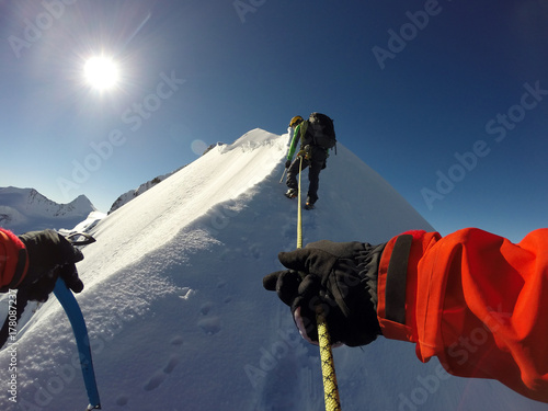 A mountaineer climps his way to the peak of Piz Bernina in the Swiss Alps. photo