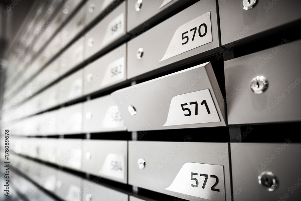 Mail boxes filled of leaflets and letters. Shallow DOF,Mailboxes and Lock in Rows at Entrance. Mail boxes filled of leaflets and letters. Shallow DOF,Mailboxes and Lock in Rows at Entrance.