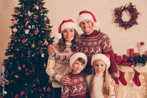 Four cheerful beautiful bonding relatives, at home, married couple, mom and dad, excited siblings, in knitted cute traditional x mas costumes, so excited about x mas noel coming!
