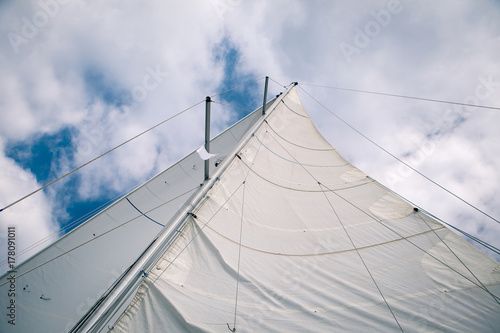 White sail in the wind on the boat, view from below